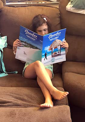 Girl reading a Beaches Resorts brochure