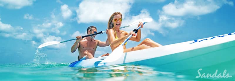 Happy couple in kayak at Sandals Resorts